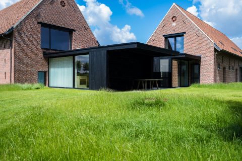 Moderne aanbouw hoevewoning in houtskelet bekleed met gebrand hout