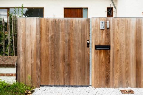 Houten tuinpoort naast schuifpoort