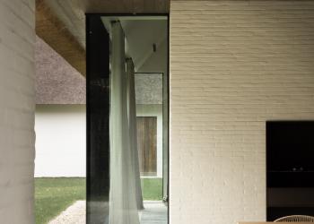 Houten plafond in Ipé kleur contrasteert mooi met witte gevel van overdekt terras