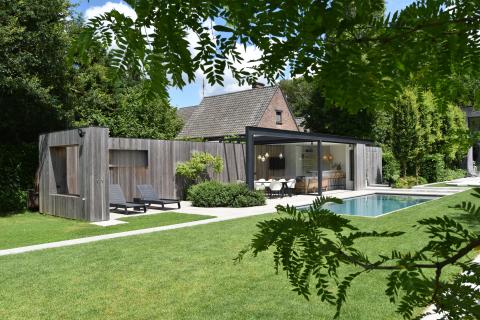 Houten bijgebouw met poolhouse, tuinberging en omheind terras