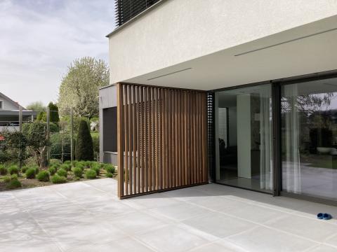 Houten shutter met beweegbare lamellen voor privacy en bescherming op terras woning