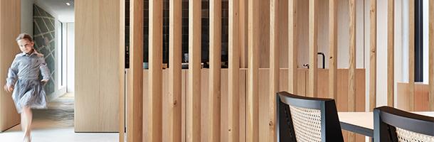 Houten roomdivider met verticale lamellen tussen keuken en eetkamer