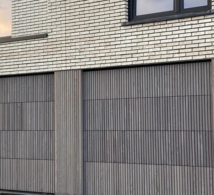 Houten gevelbekleding garagepoort woning Jabbeke