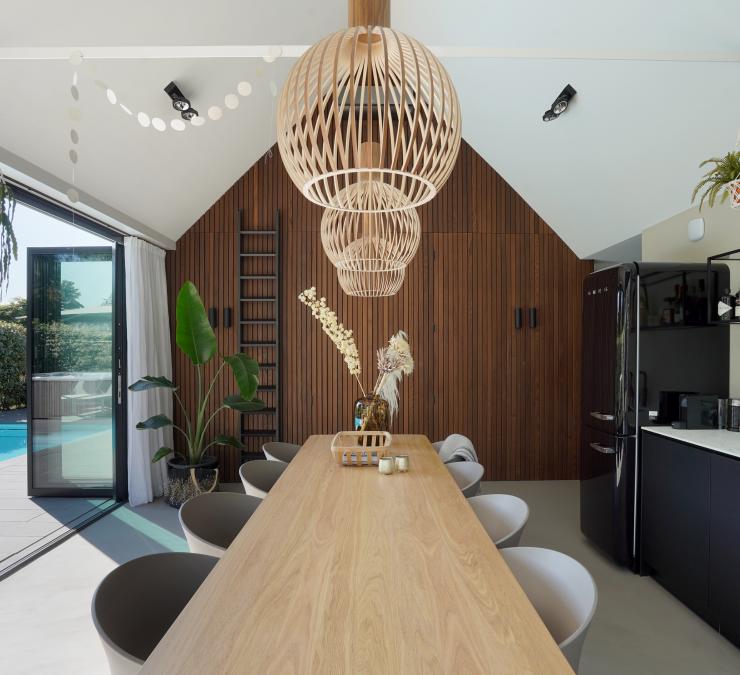 Houten wand brengt warmte in poolhouse