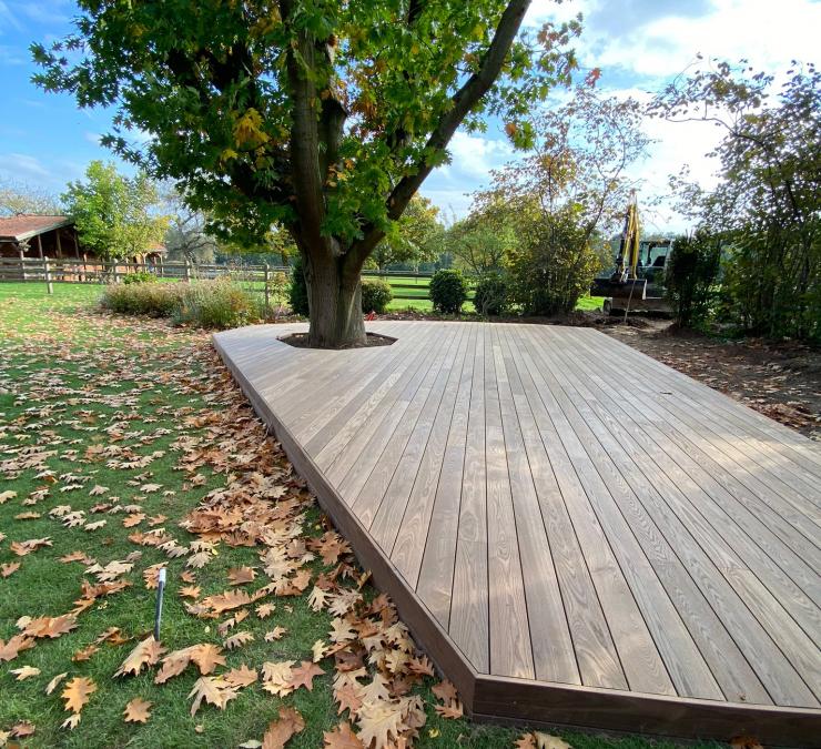 Houten terras achterin de tuin met bol geschaafde terrasplanken in HOTwood essen