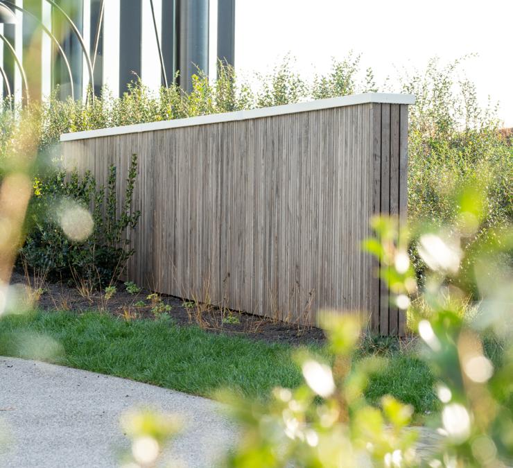 Houten omheining in thermisch essen Fine line QC met witte afdekplaat