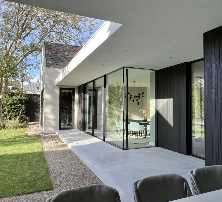 Zwarte houten gevelbekleding en grote raampartijen geeft moderne touch aan woning