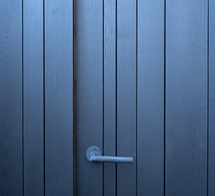 Zwarte deur vervaardigd met houten planken van wisselende breedtes