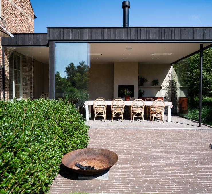 Zwart houten bijgebouw aangebouwd aan woning