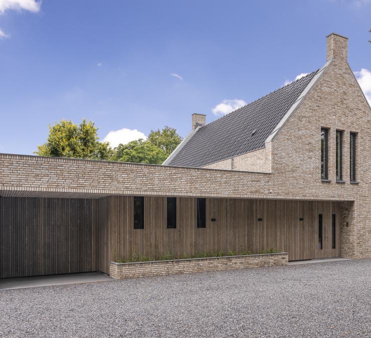 Villa met robuuste gevelsteen en voorvergrijsde houten gevelbekleding