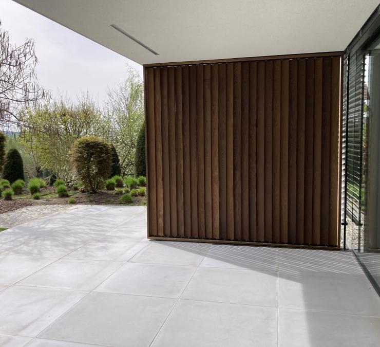 Gesloten houten shutter zorgt voor privacy en bescherming tegen wind op terras