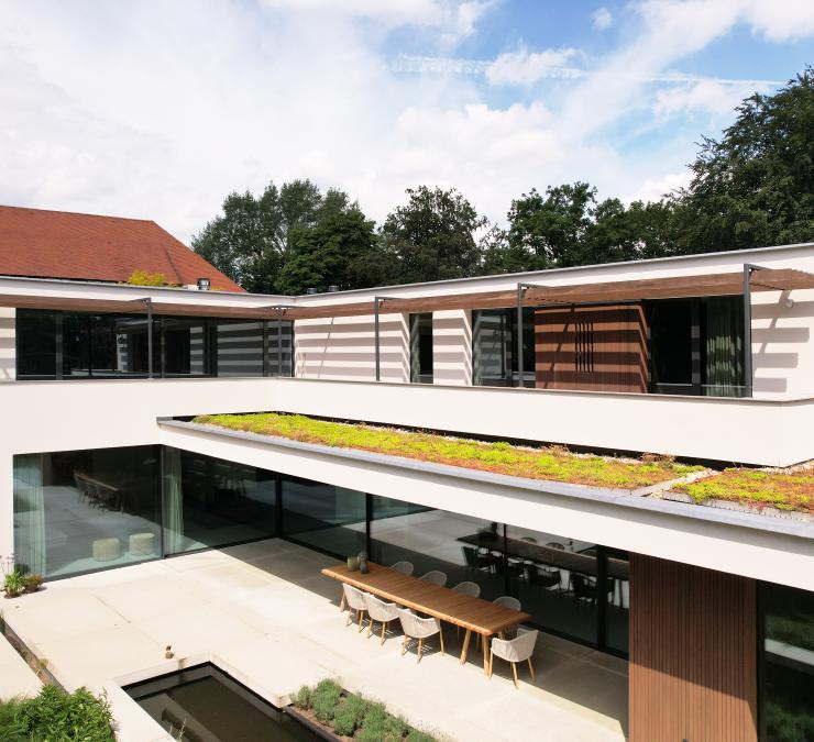 Houten zonneluifel als zonwering bij villa met groendak