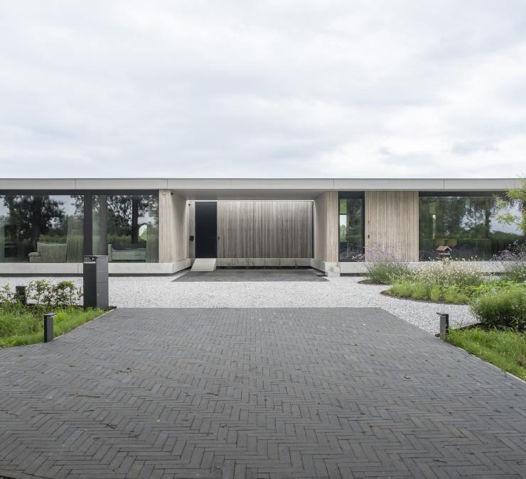 Industriële bungalow in beton met hout als warm accent in de gevel
