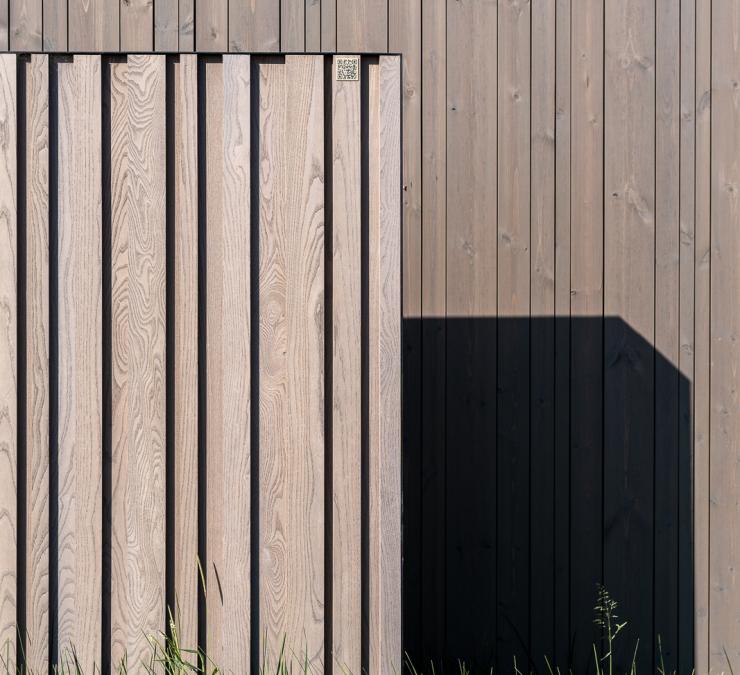 Houten schuifpoort en naaldhout gevelbekleding afgewerkt in kleur taupe
