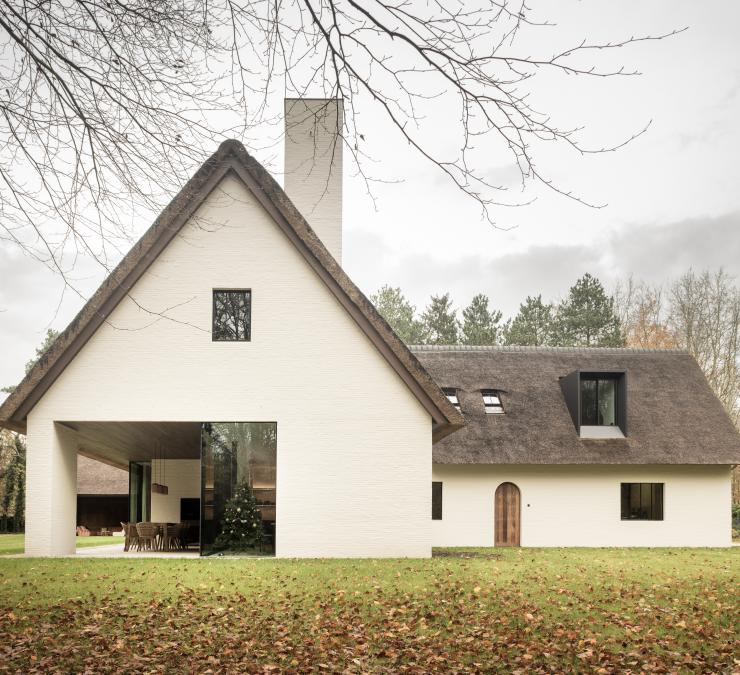 Witte villa met rietdak en houten bekleding in thermisch essen Ipé kleur