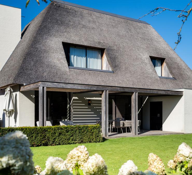 Woning met harmonieuze combinatie van vergrijsd essenhout, rieten dak en witte muren