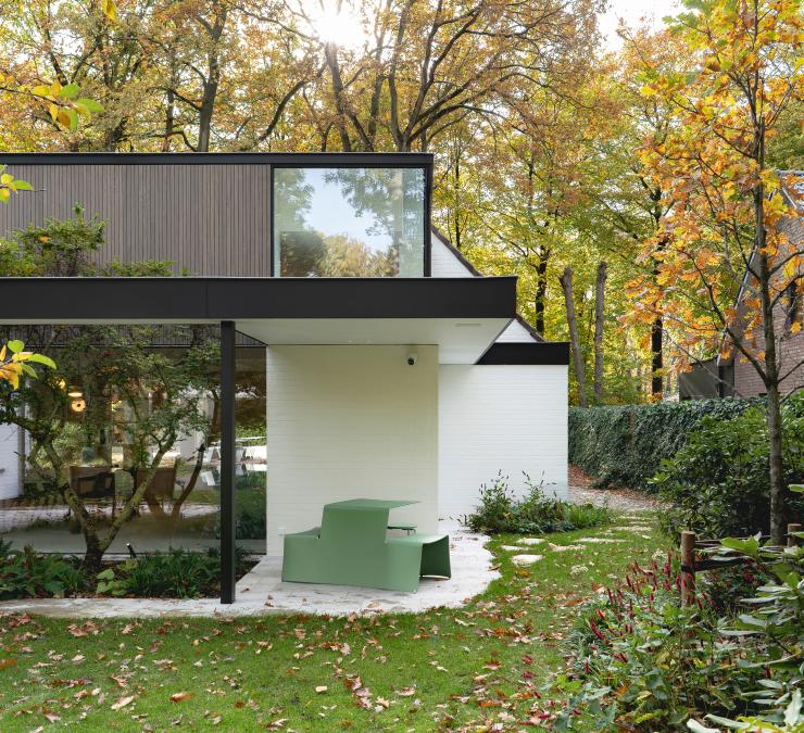 Strakke witte villa met houten gevelbekleding in thermisch essen