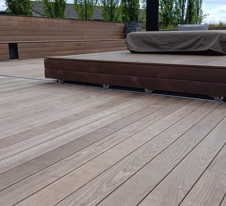 Warm totaalbeeld in thermisch essen: terras, zitbank en strakke randafwerking
