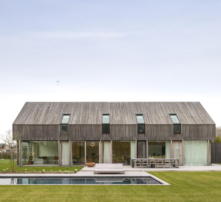 House in rural surroundings with large picture windows and timber cladding